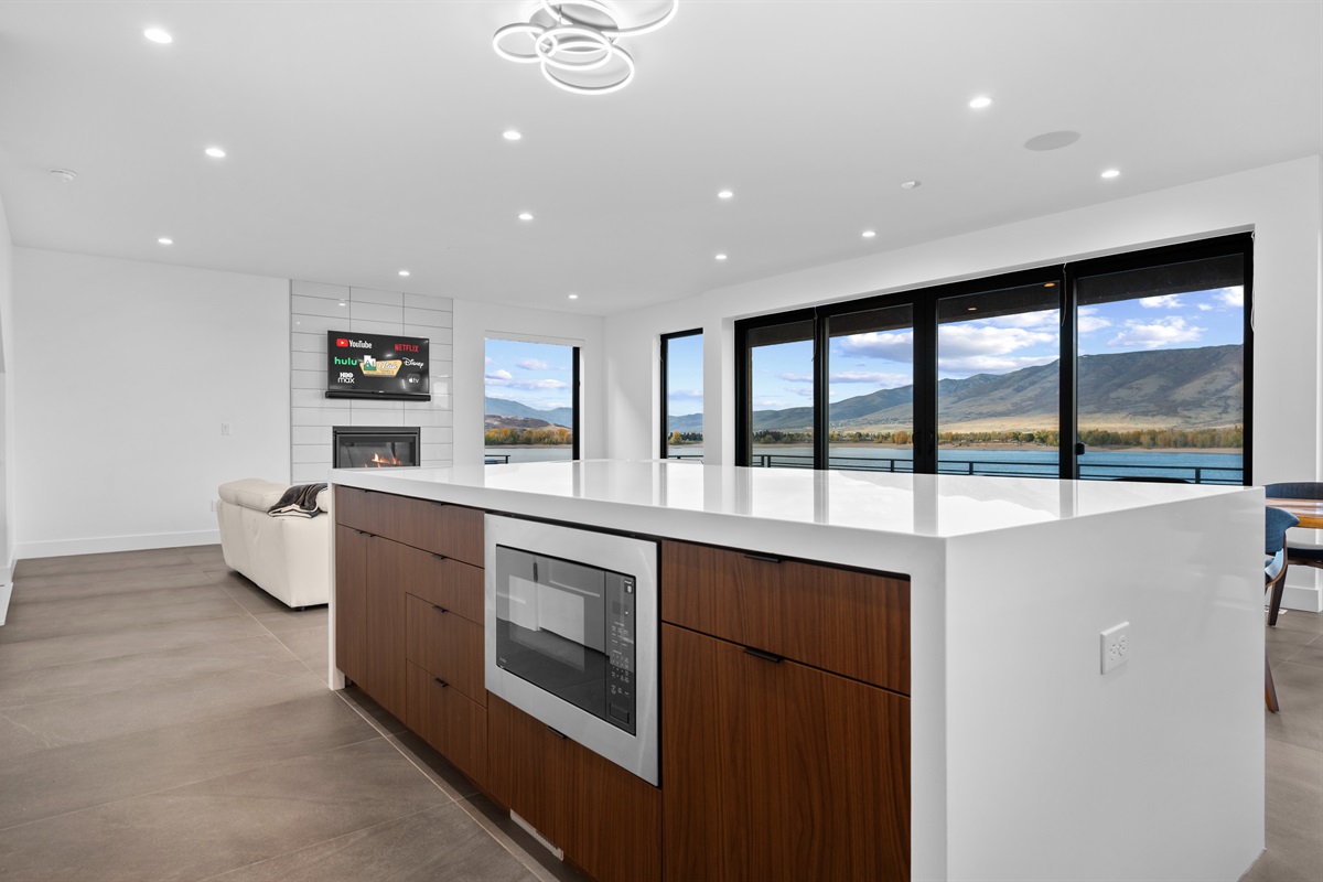 Modern kitchen island with built-in microwave and stunning lake backdrop.