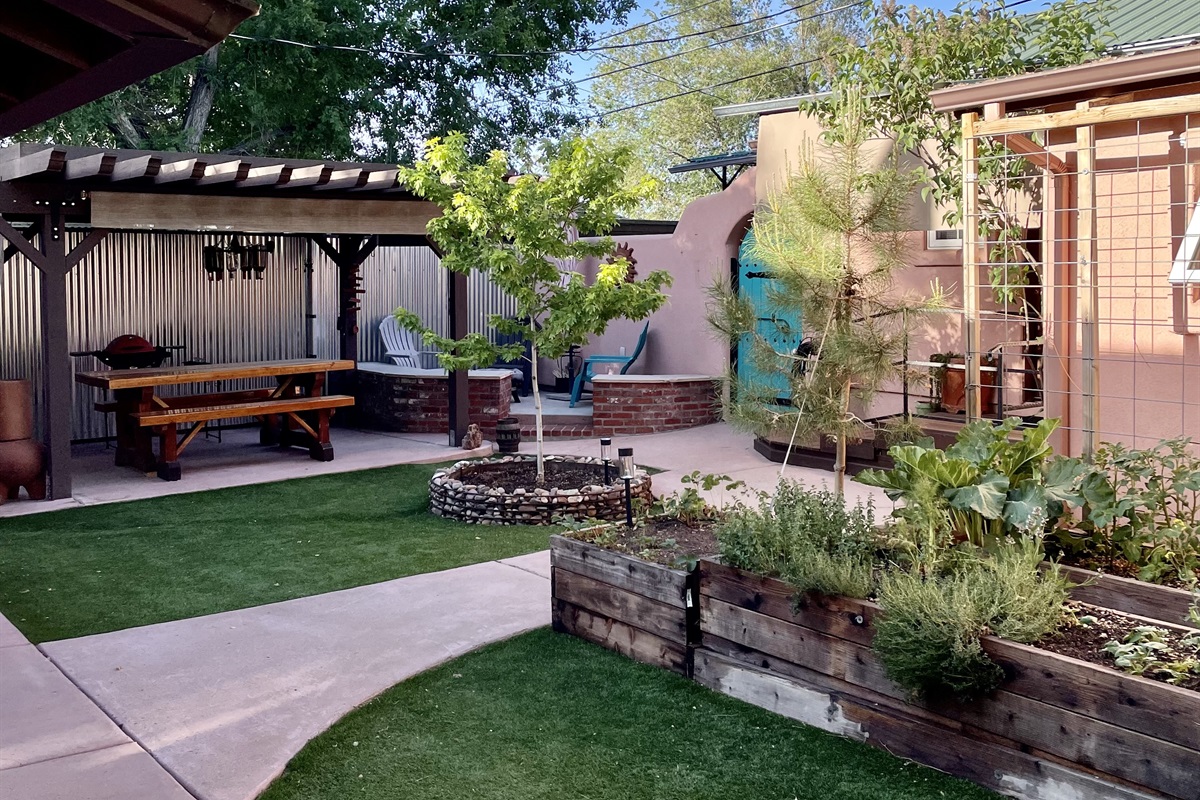 Escape to this tranquil courtyard oasis, complete with a picnic table, grill, fire pit, and lush greenery.