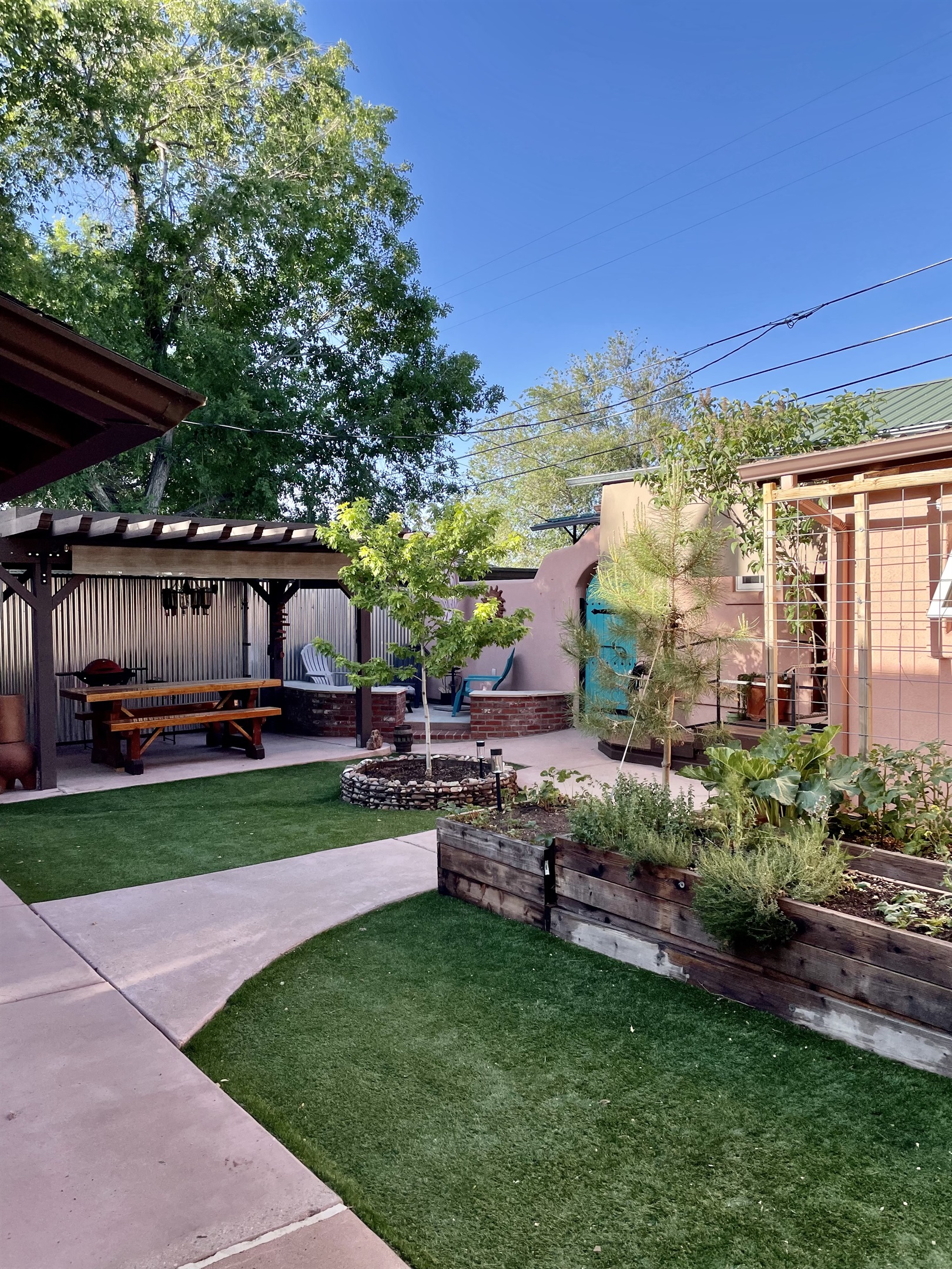 Escape to this tranquil courtyard oasis, complete with a picnic table, grill, fire pit, and lush greenery.