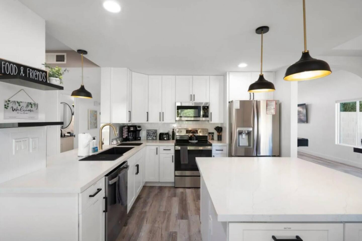Bright, airy kitchen with island, stainless steel appliances, and abundant counter space.