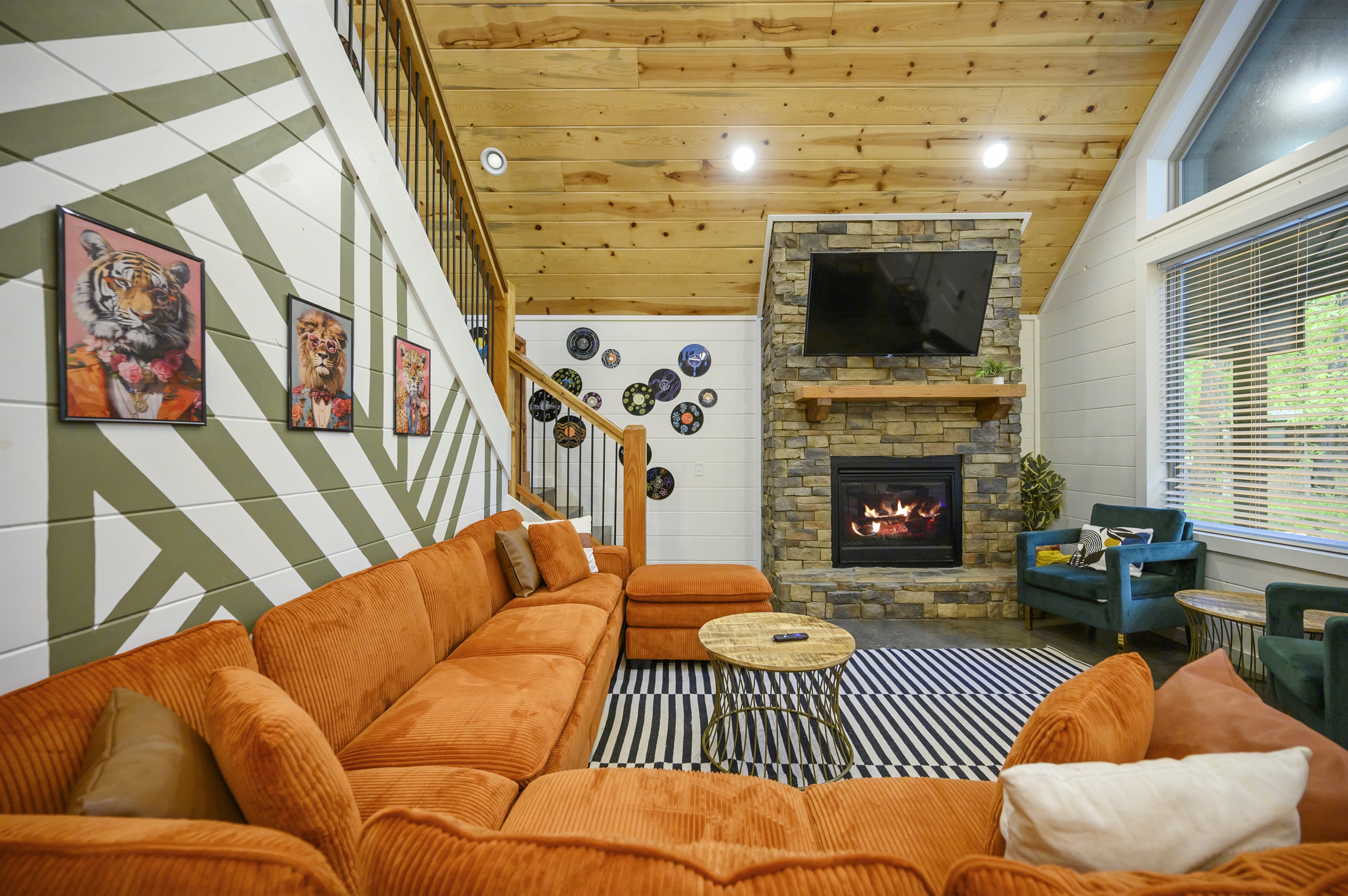 Open living room with stone fireplace, sectional seating and music-inspired design.