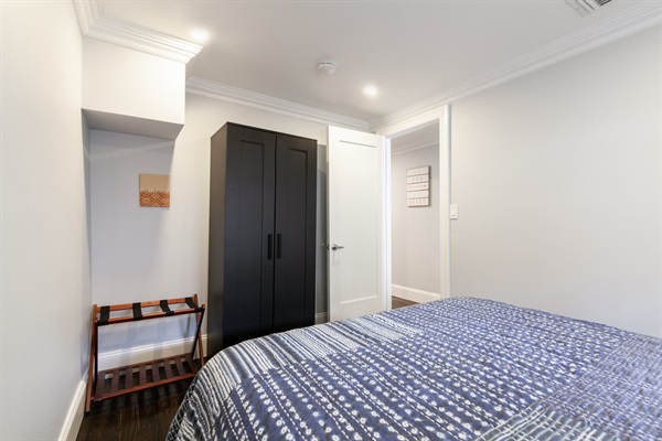 Second bedroom (view of dresser) and luggage holder. 