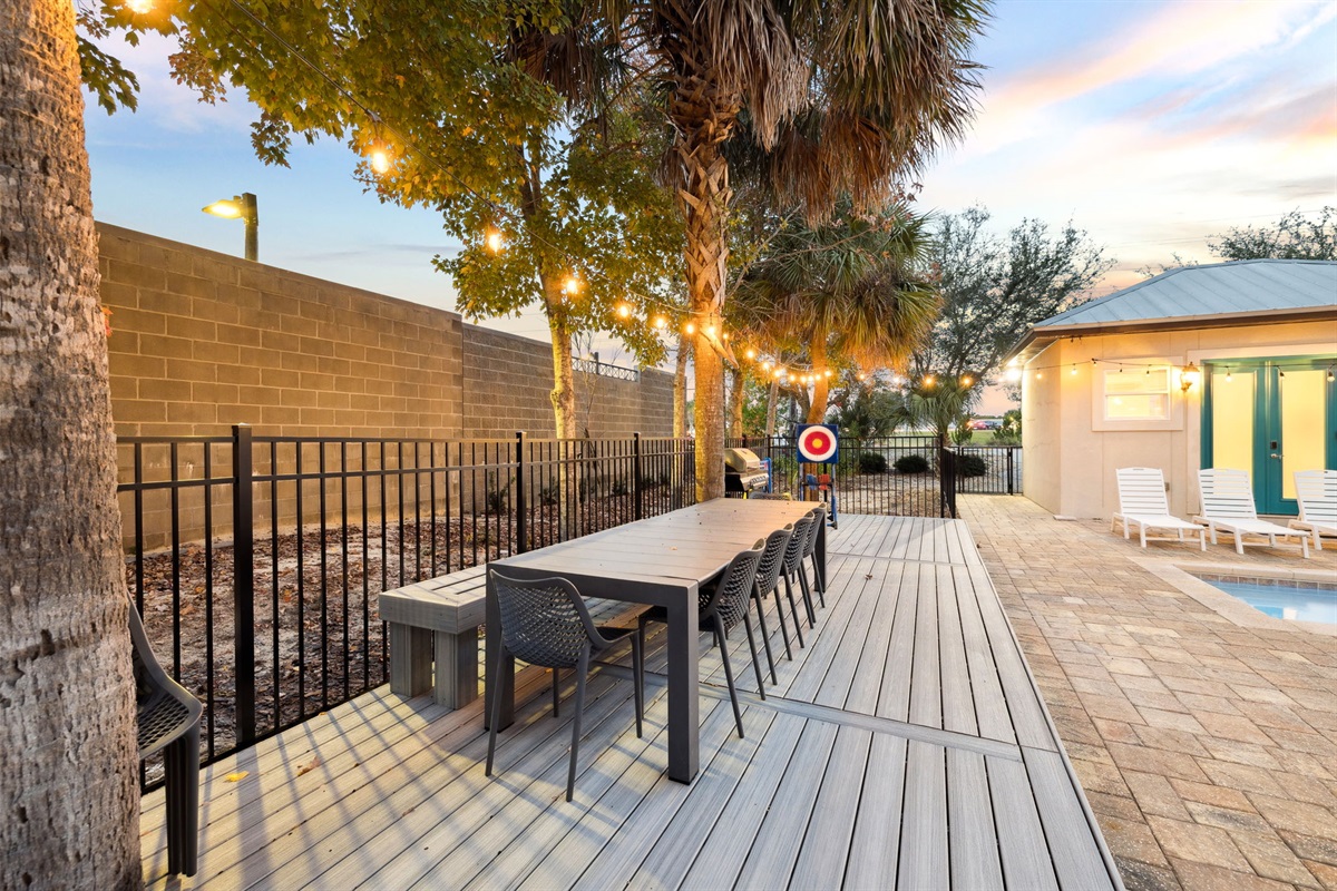 A newly built deck by the pool, housing the BBQ grill, the outdoor dining table, and some outdoor games.