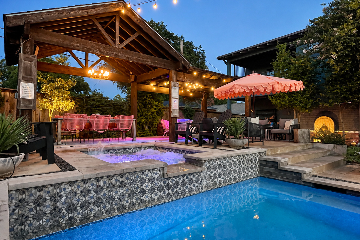 Hot tub and veranda glowing at twilight at The Style Studio, a Fort Worth private pool retreat.
