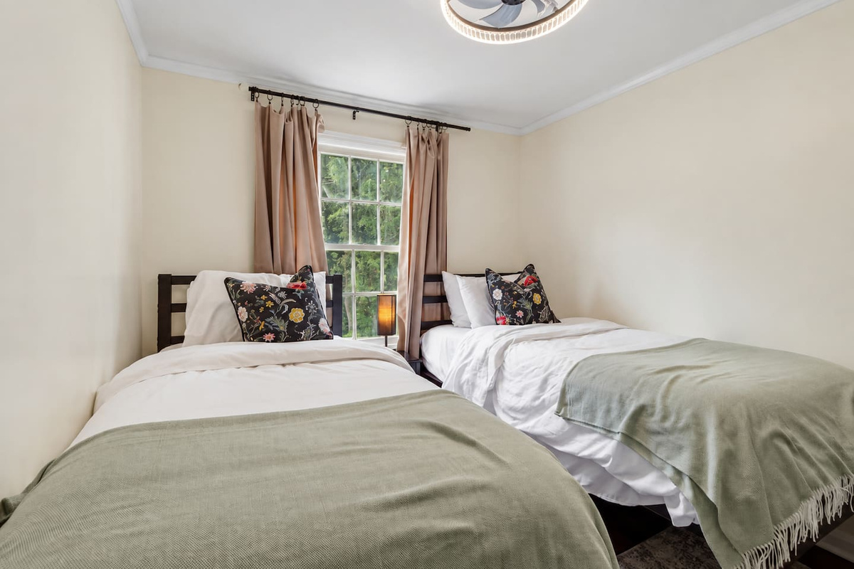 Cozy bedroom three, with two twin beds, a dresser, and a smart TV for added comfort.