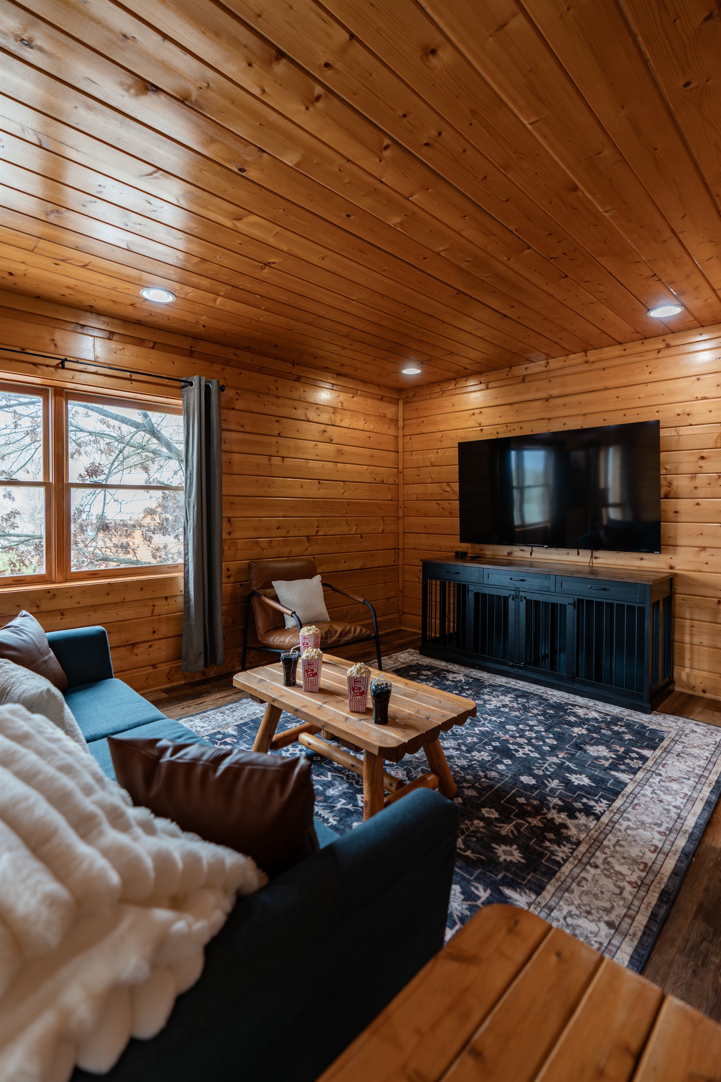Movie night on the lower level — 75" Smart TV, couch with throw blankets, popcorn on the coffee table. The kids don't want to leave. Honestly, neither do the adults.