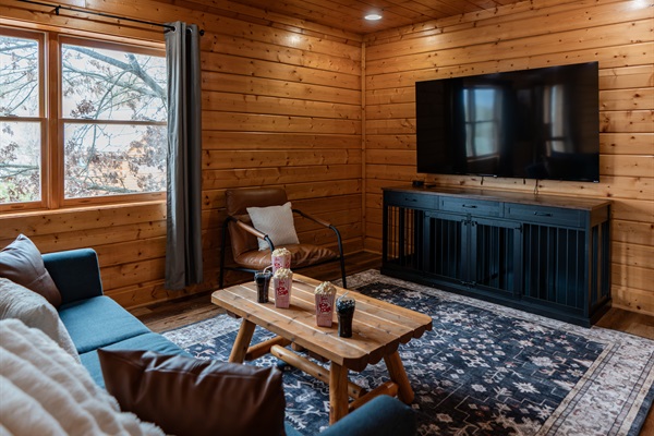 Movie night on the lower level — 75" Smart TV, couch with throw blankets, popcorn on the coffee table. The kids don't want to leave. Honestly, neither do the adults.