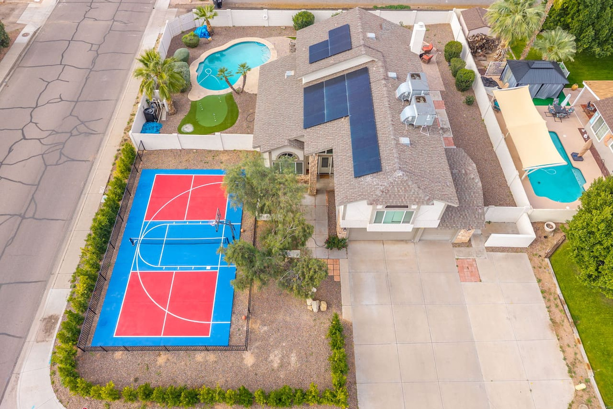 Aerial view of resort compound featuring sports court, multiple pools, solar power, and extensive outdoor entertaining spaces.