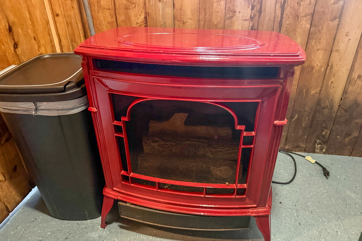Primary heat source at Loonrise Point! Classic red enamel heater stove provides cozy warmth for chilly mornings and cool evenings. Easy-to-use heating option inside our uninsulated seasonal camp on Beech Hill Pond in Otis, ME.
