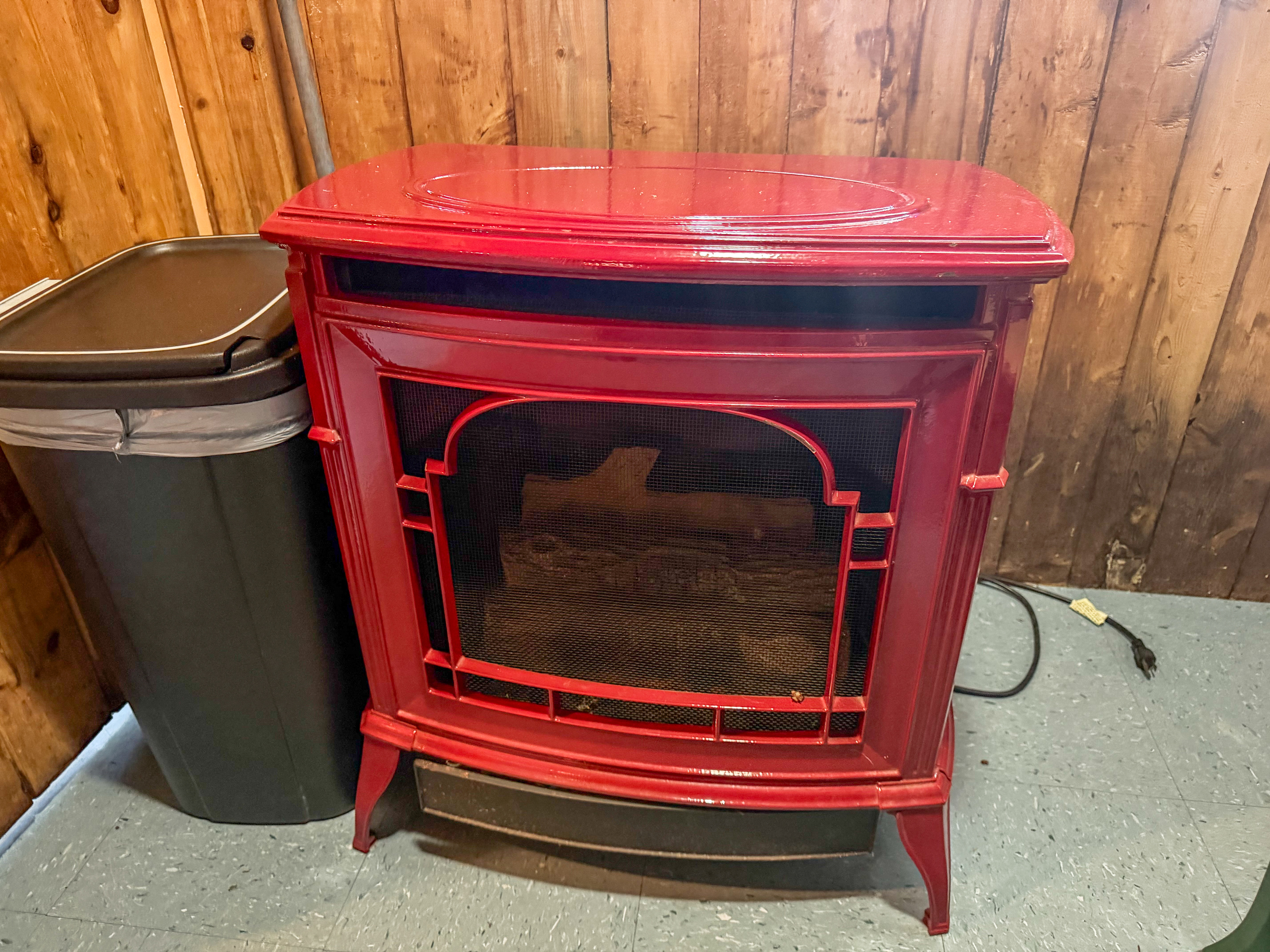 Primary heat source at Loonrise Point! Classic red enamel heater stove provides cozy warmth for chilly mornings and cool evenings. Easy-to-use heating option inside our uninsulated seasonal camp on Beech Hill Pond in Otis, ME.