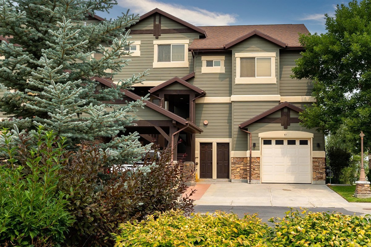 Charming mountain-style exterior with rich wood and stone accents, nestled in a peaceful lakeside community.