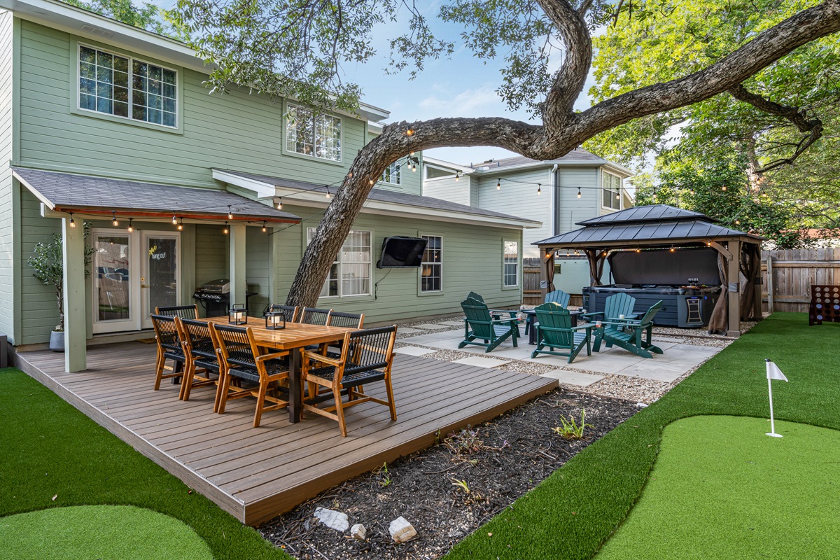 Unwind in this backyard oasis! Perfect your putt on the green, relax in the hot tub, or gather around the fire pit with friends. With an outdoor TV & spacious dining area, it’s the ultimate spot for fun, relaxation, & making memories under the stars.