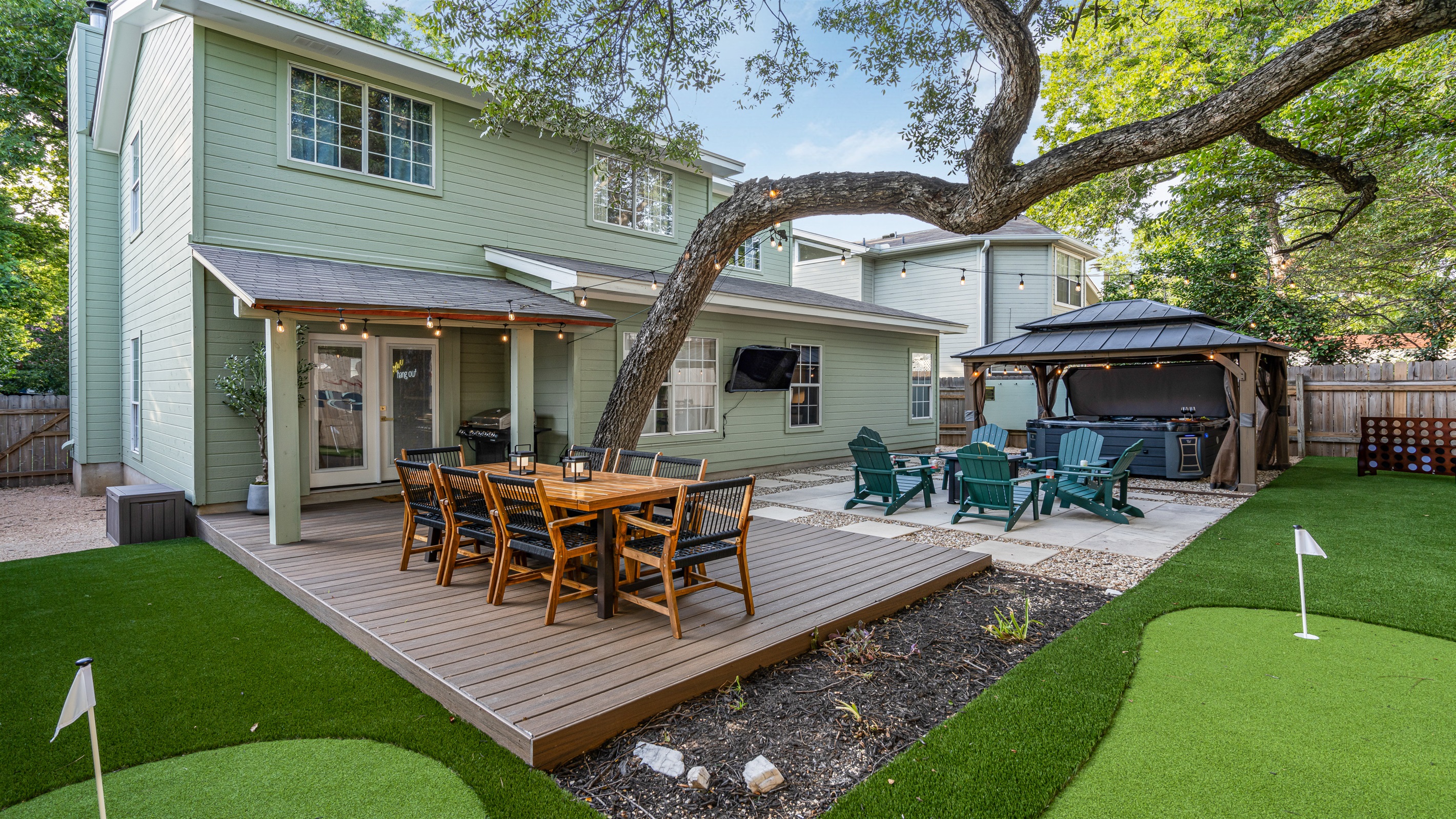 Unwind in this backyard oasis! Perfect your putt on the green, relax in the hot tub, or gather around the fire pit with friends. With an outdoor TV & spacious dining area, it’s the ultimate spot for fun, relaxation, & making memories under the stars.