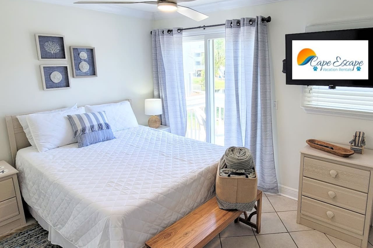 The queen bedroom on the main level has its own Smart TV and sits steps from the main bath &mdash; your own quiet corner after a long day on the water.