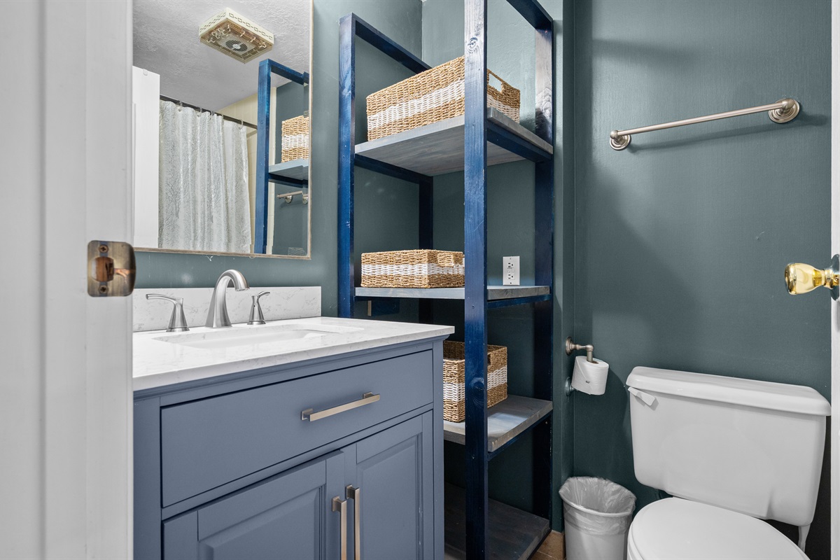 Clean and modern bathroom with shower/tub combination and plenty of fresh towels.