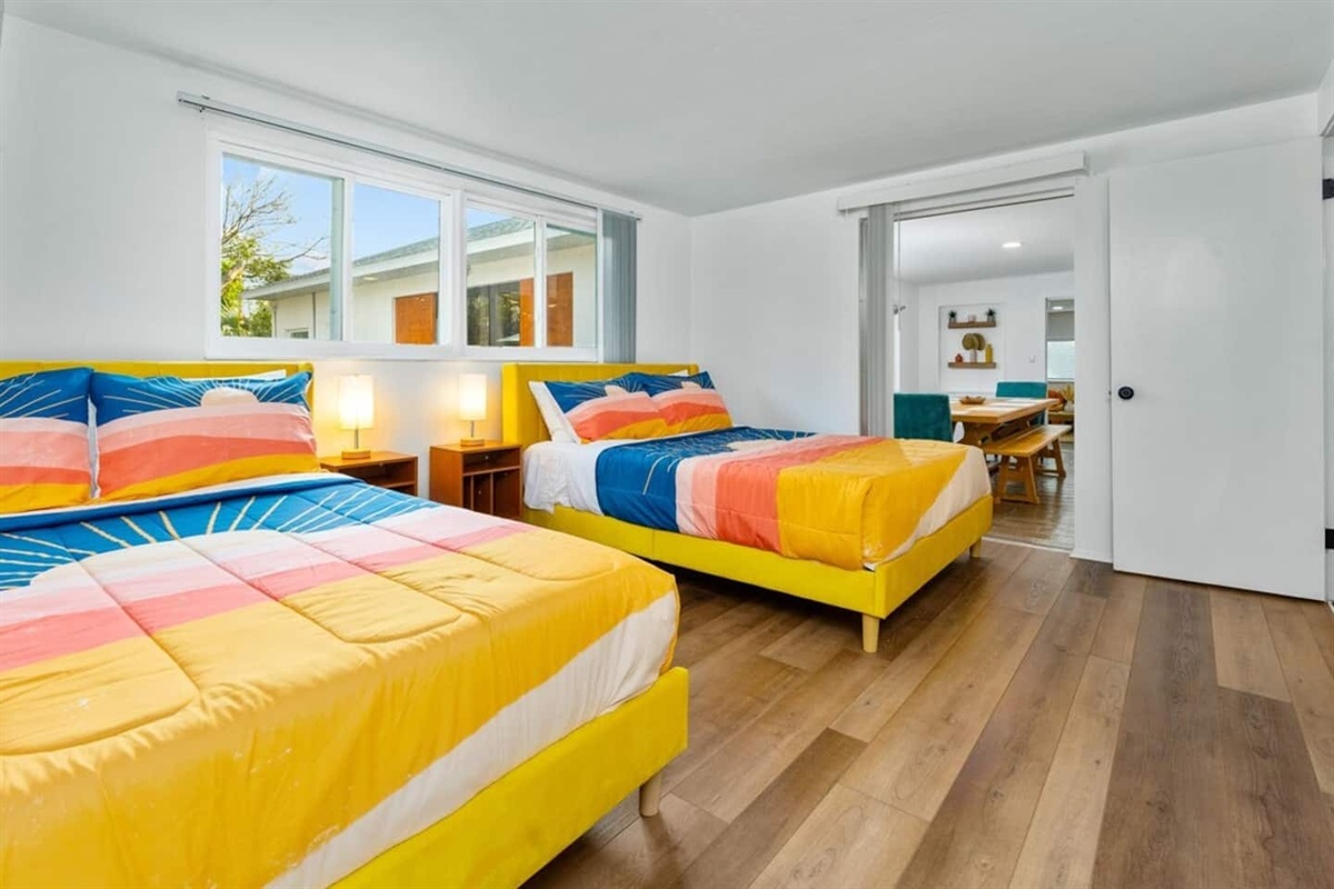 Bedroom with 2 queen size beds. Glass door opens to the dining room and overlooks the pool.