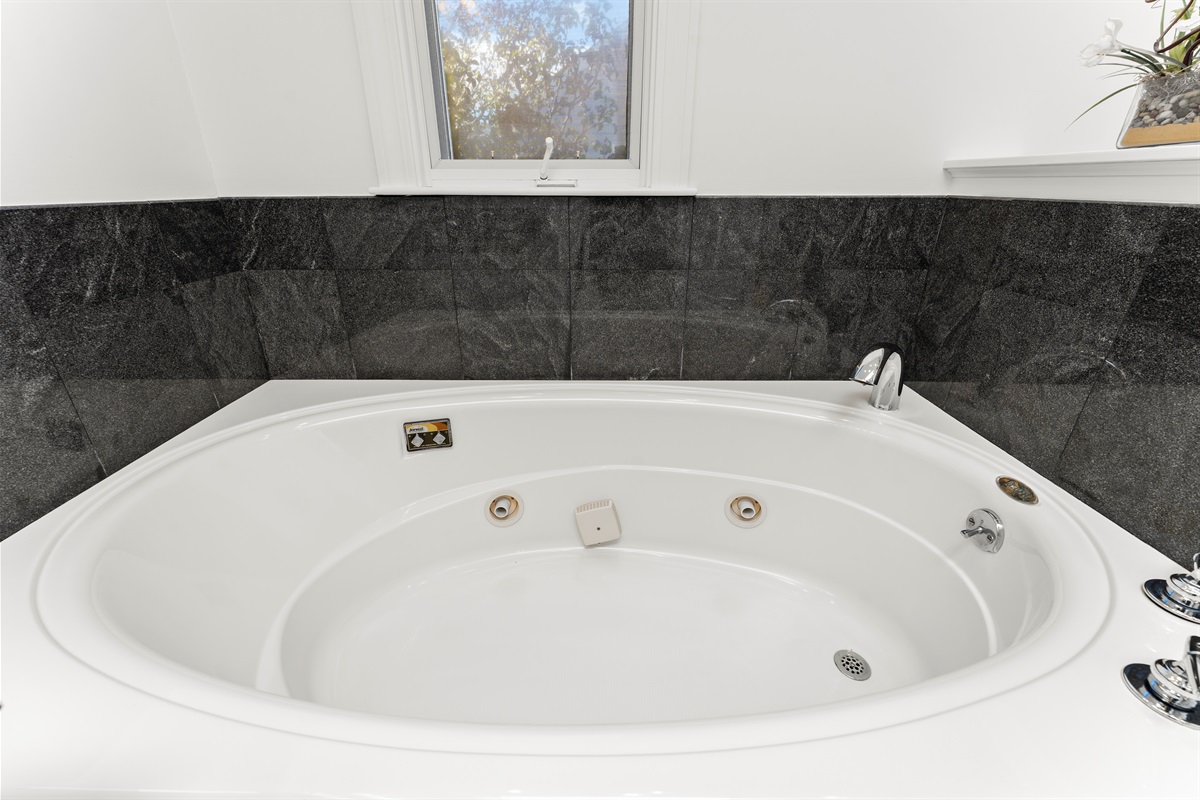Relax in the queen ensuite featuring a jetted tub and standing shower.