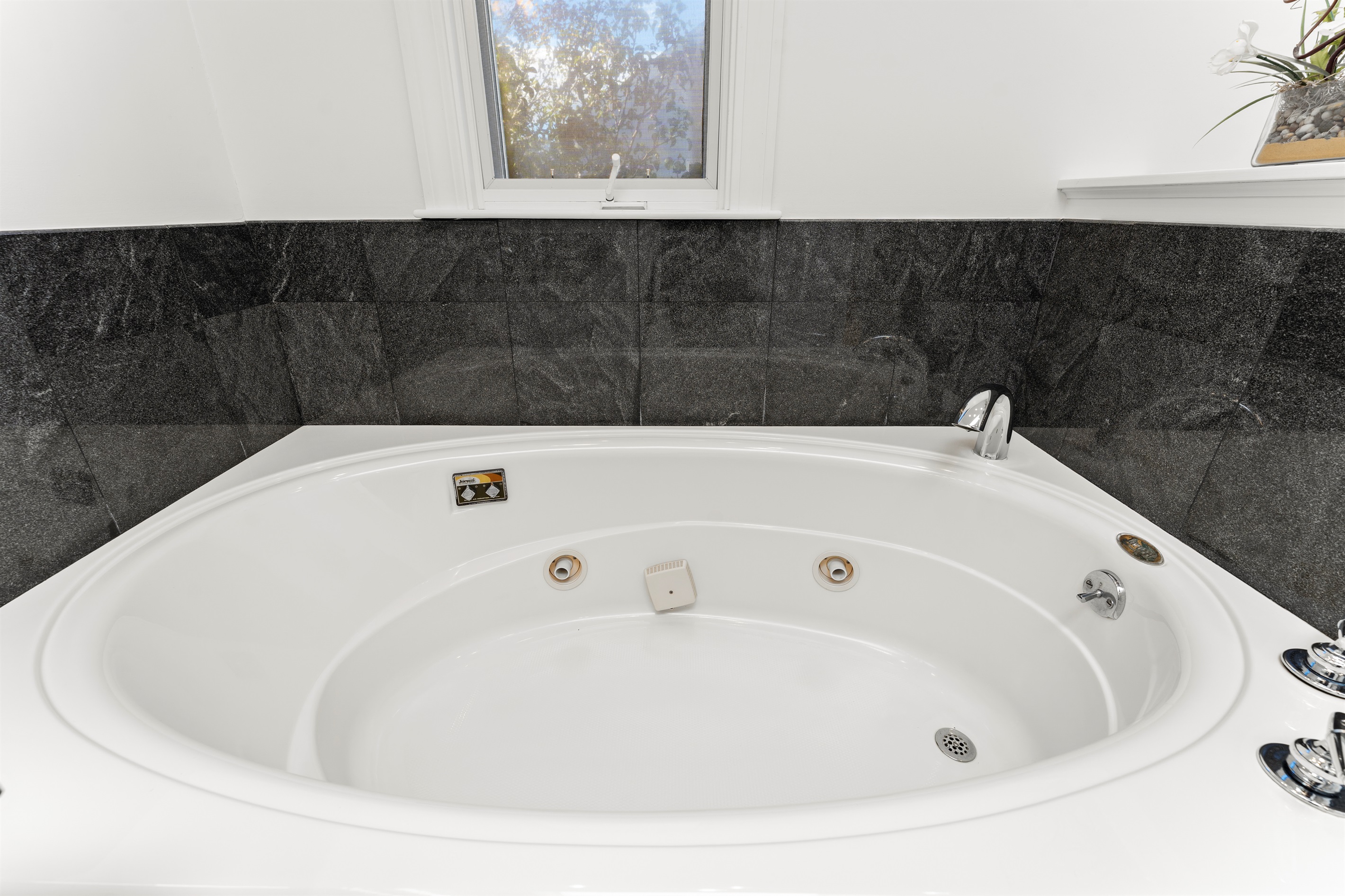 Relax in the queen ensuite featuring a jetted tub and standing shower.