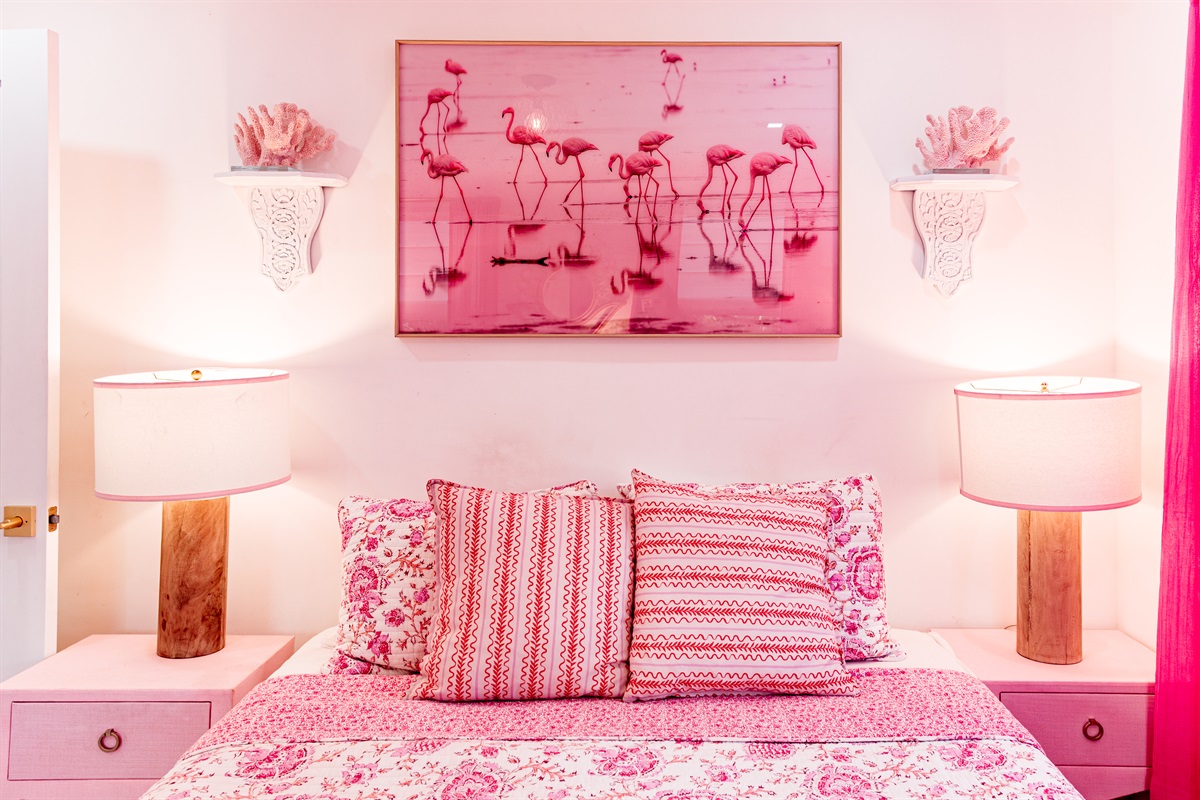 The second cottage bedroom is draped in themes of red and pink, a colorful and comfortable place to relax for a long evening's rest.