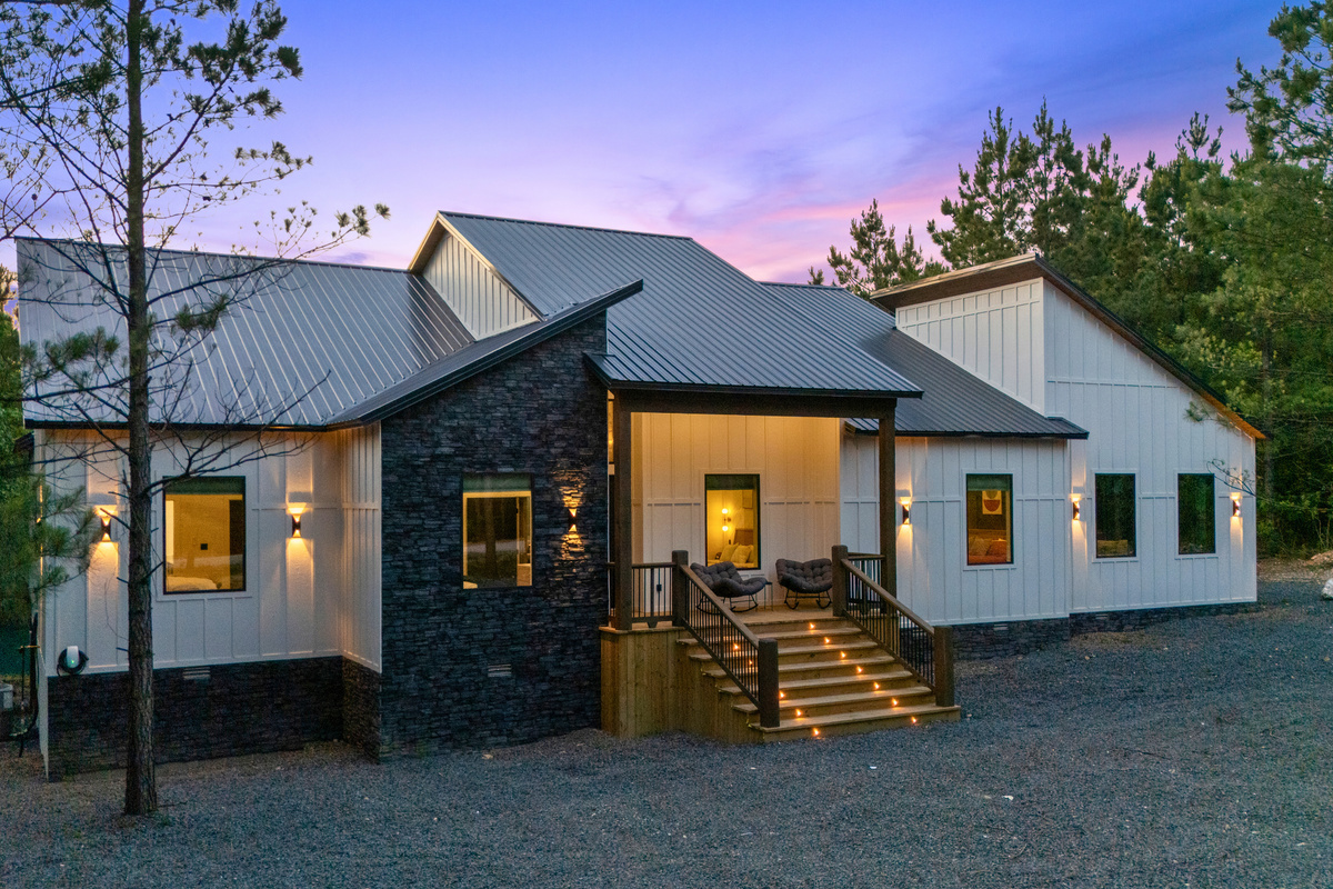 Warm exterior lighting and modern farmhouse-inspired design give the cabin incredible curb appeal that feels especially inviting at dusk.
