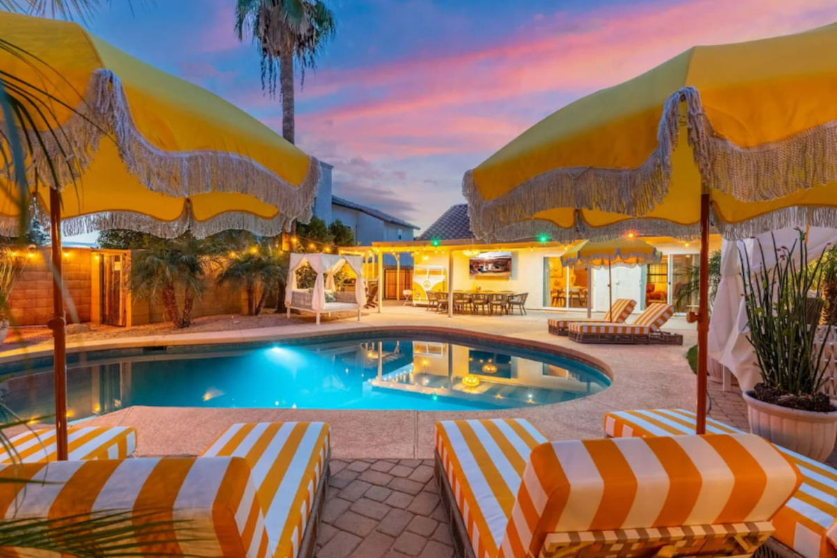 A cozy umbrella nook with lounge chairs offers a quiet corner beside the pool.