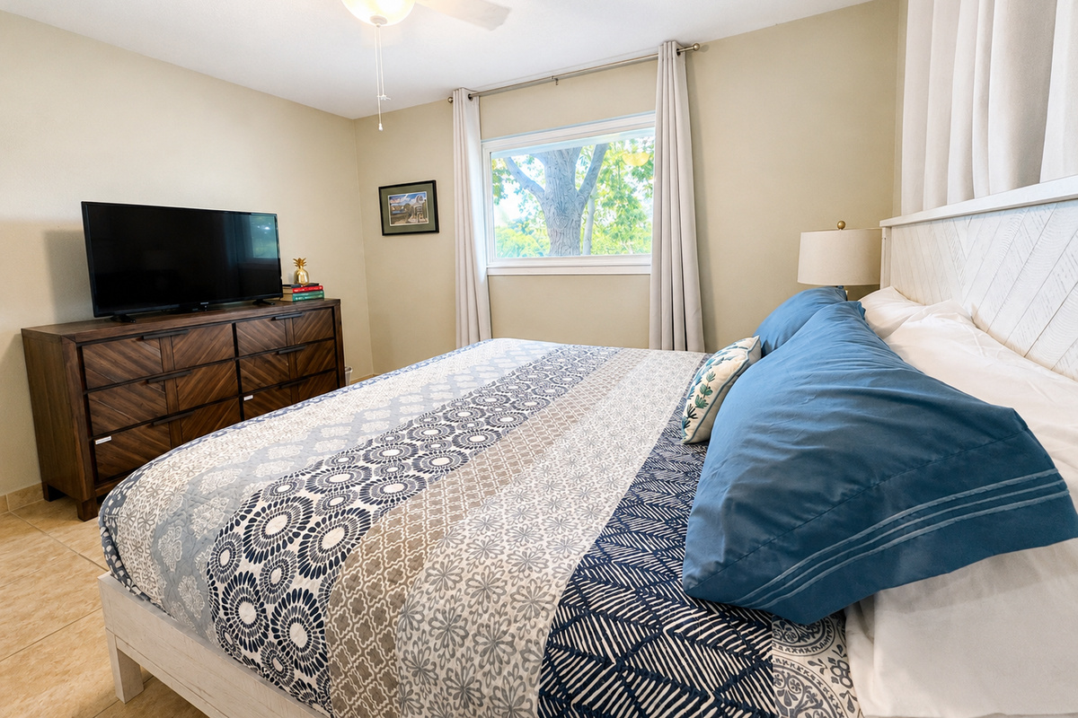 King bedroom w/ smart TV, darkening curtains, and lake view