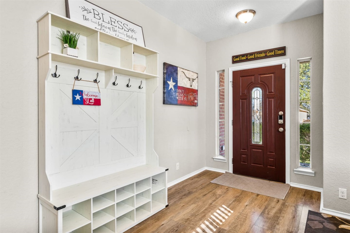 Front entry with convenient coat hooks and shoe storage, creating an organized and welcoming arrival space.