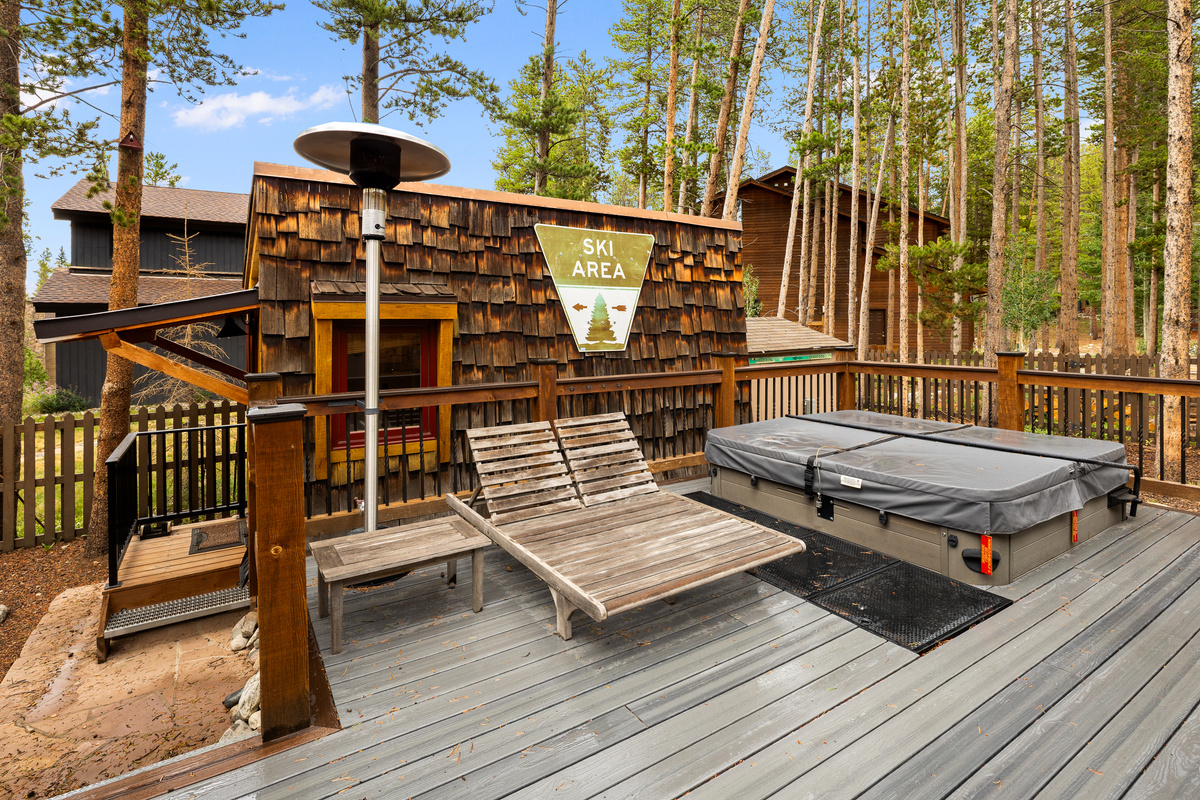 Large outdoor living space with in-ground hot tub, lounge seating, outdoor heaters and backyard bungalow. 