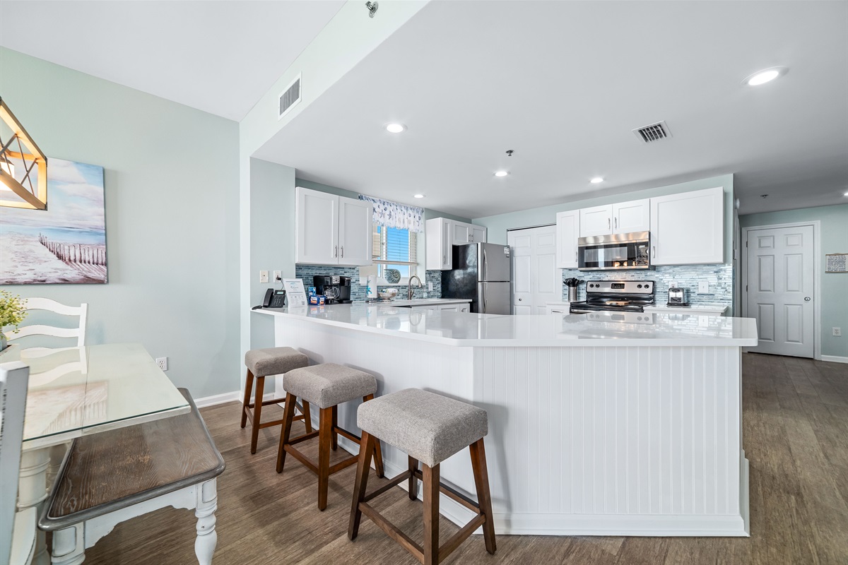 Dine in style with ample space for everyone. This inviting dining area features a charming table for family meals, complemented by additional seating at the convenient breakfast bar.