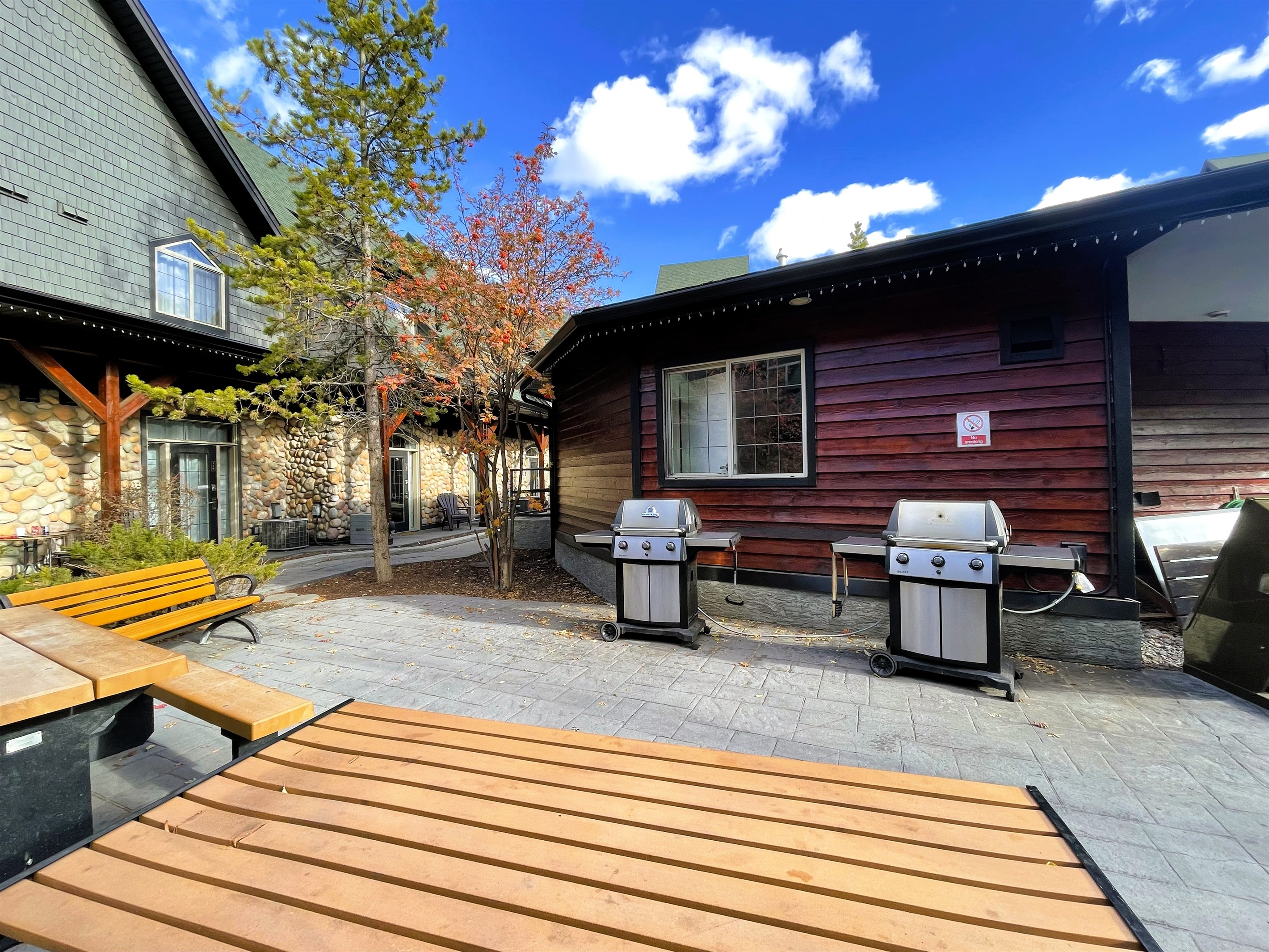 Shared BBQ area with picnic tables located in beautiful open space main courtyard.