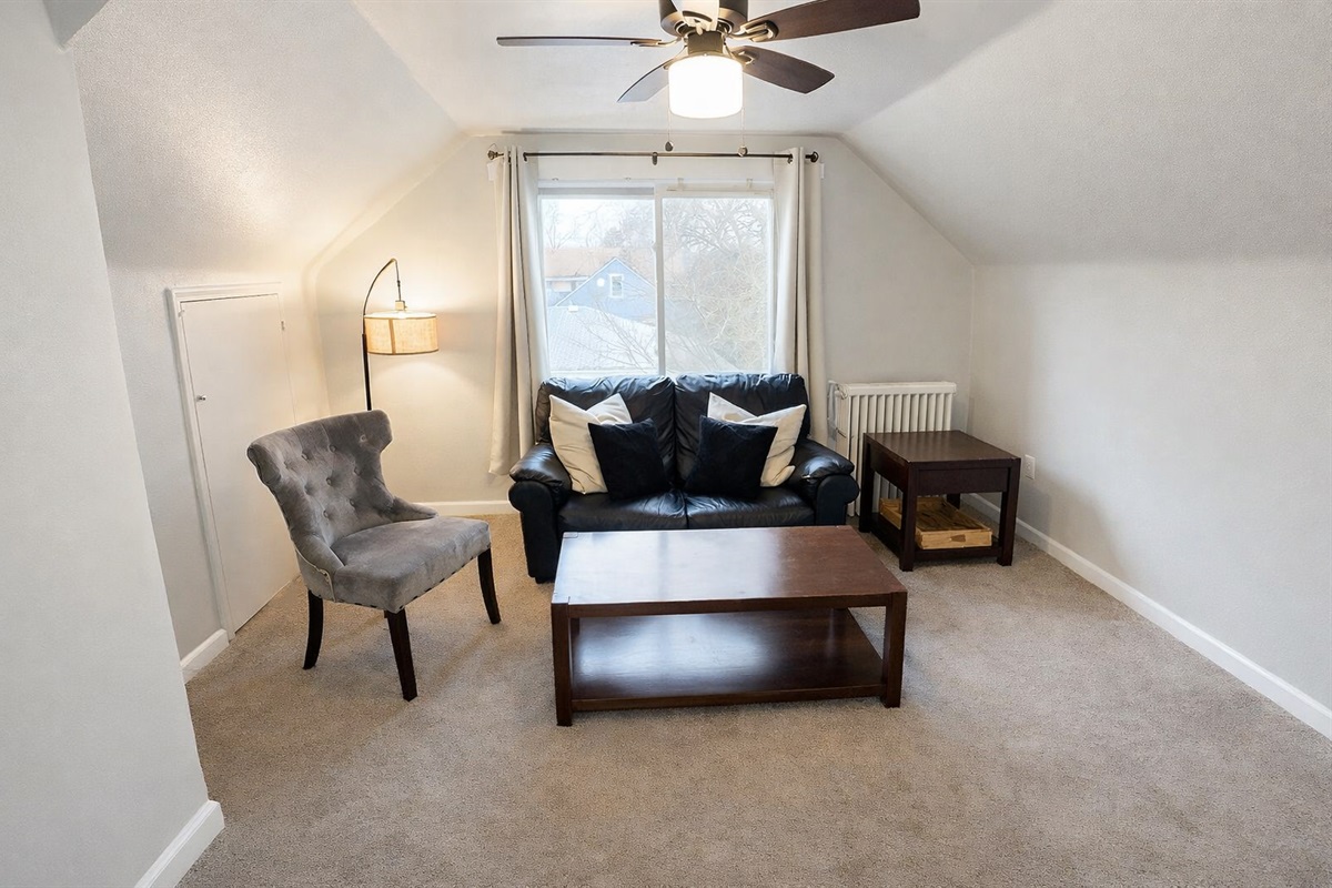 The inviting living room boasts ample seating options and additional air conditioning for extra comfort during the summer months