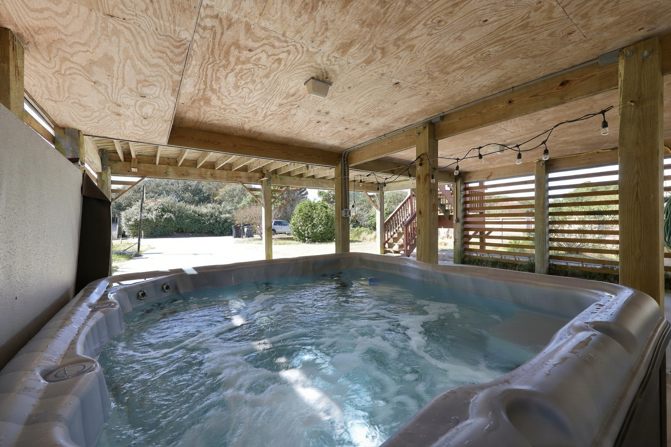 Sandy toes, meet bubbles. Soak in the hot tub under the string lights after a day on the beach.