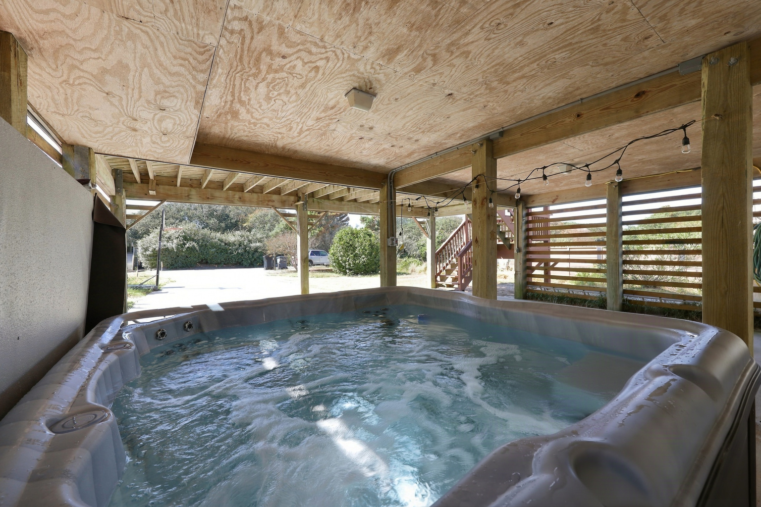 Sandy toes, meet bubbles. Soak in the hot tub under the string lights after a day on the beach.