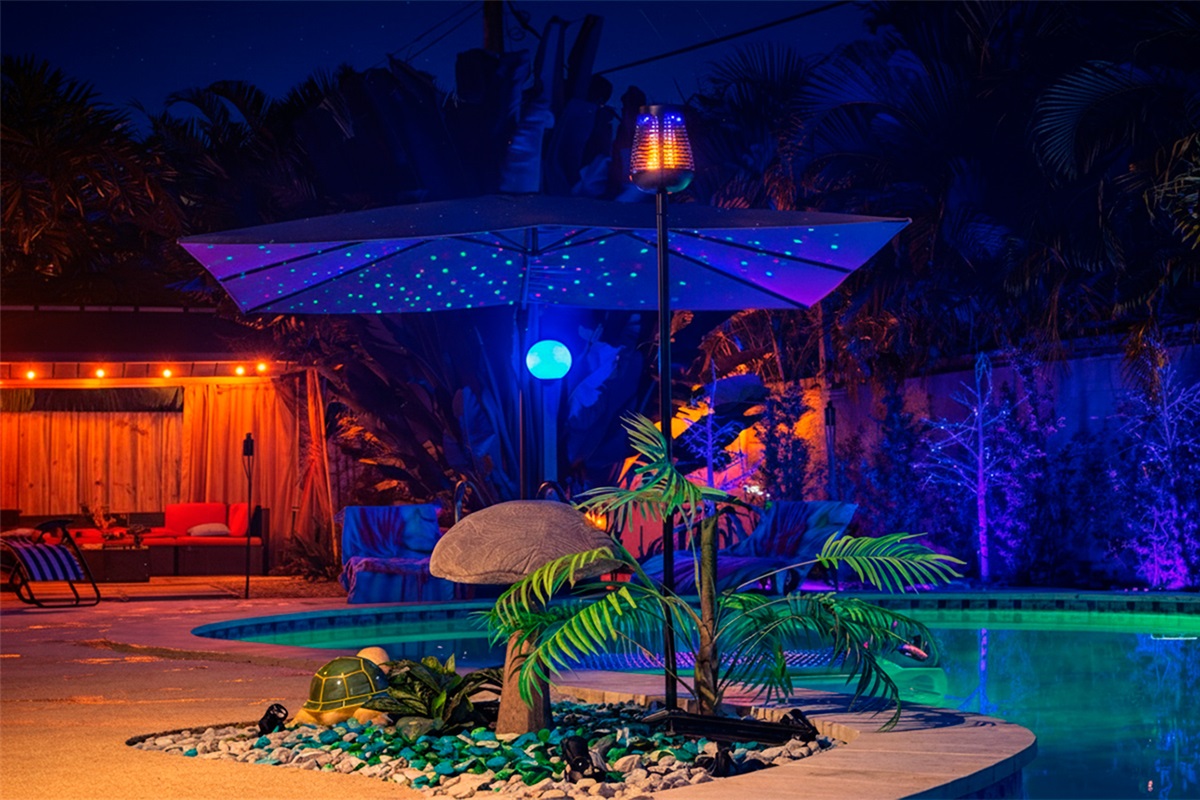 An inviting nighttime pool setting at Garden of Manors, with ambient lighting and lush tropical landscaping.