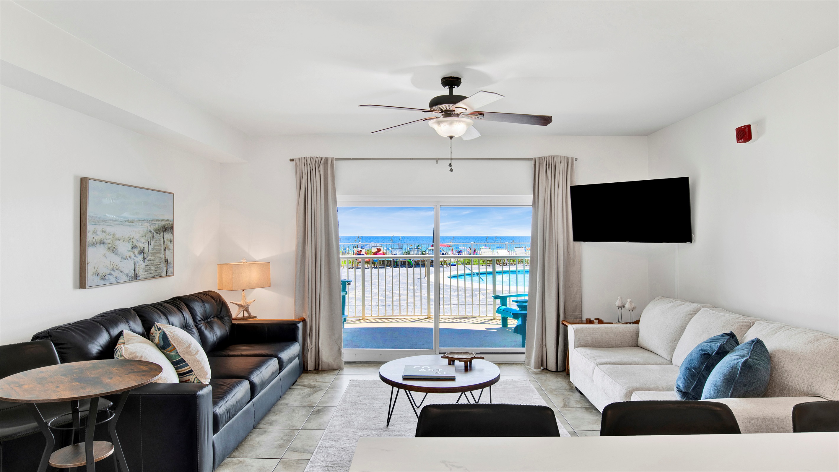 Living room with sleeper sofa, a 2nd sofa, smart TV, ceiling fan and balcony access