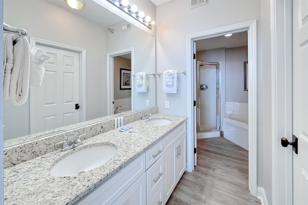 Start your day refreshed! This bright and spacious bathroom features an elegant vanity with plenty of counter space and modern fixtures, including a jetted-tub and glass walk-in shower.