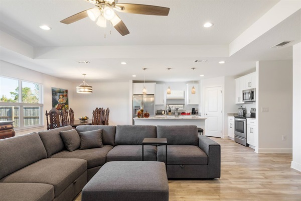 Another view of the living room with the Kitchen in the back, and dining table in the back left.