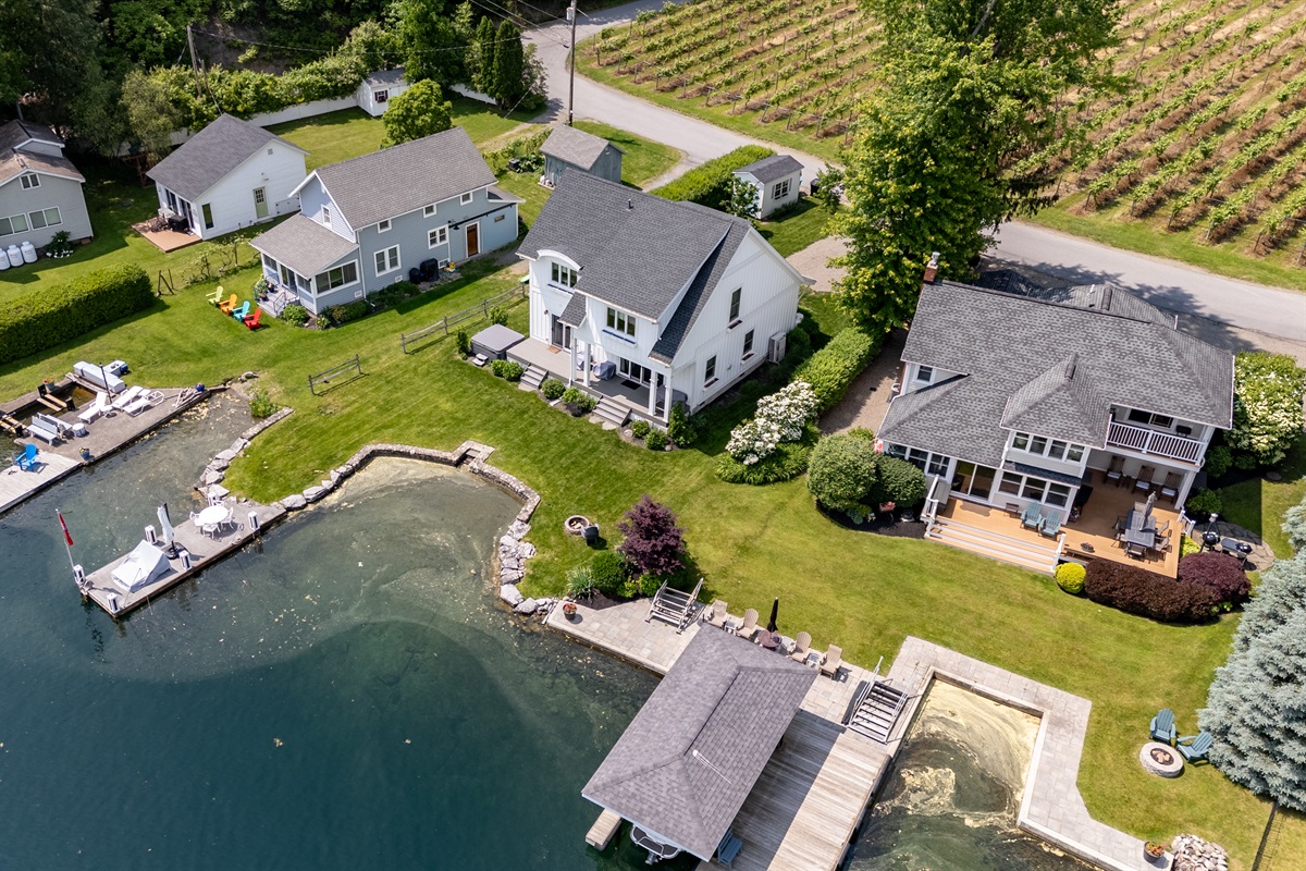 Stunning aerial view of a serene Finger Lakes waterfront retreat, complete with private dock, lush greenery, and charming lakefront homes—perfect for peaceful getaways and water adventures