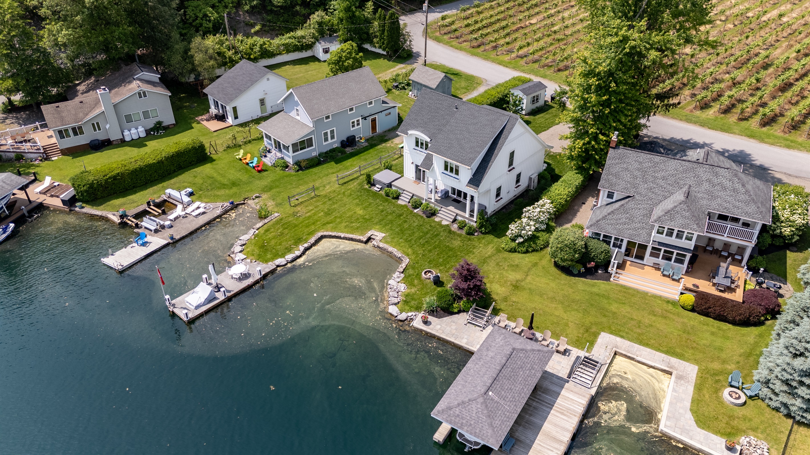Stunning aerial view of a serene Finger Lakes waterfront retreat, complete with private dock, lush greenery, and charming lakefront homes—perfect for peaceful getaways and water adventures