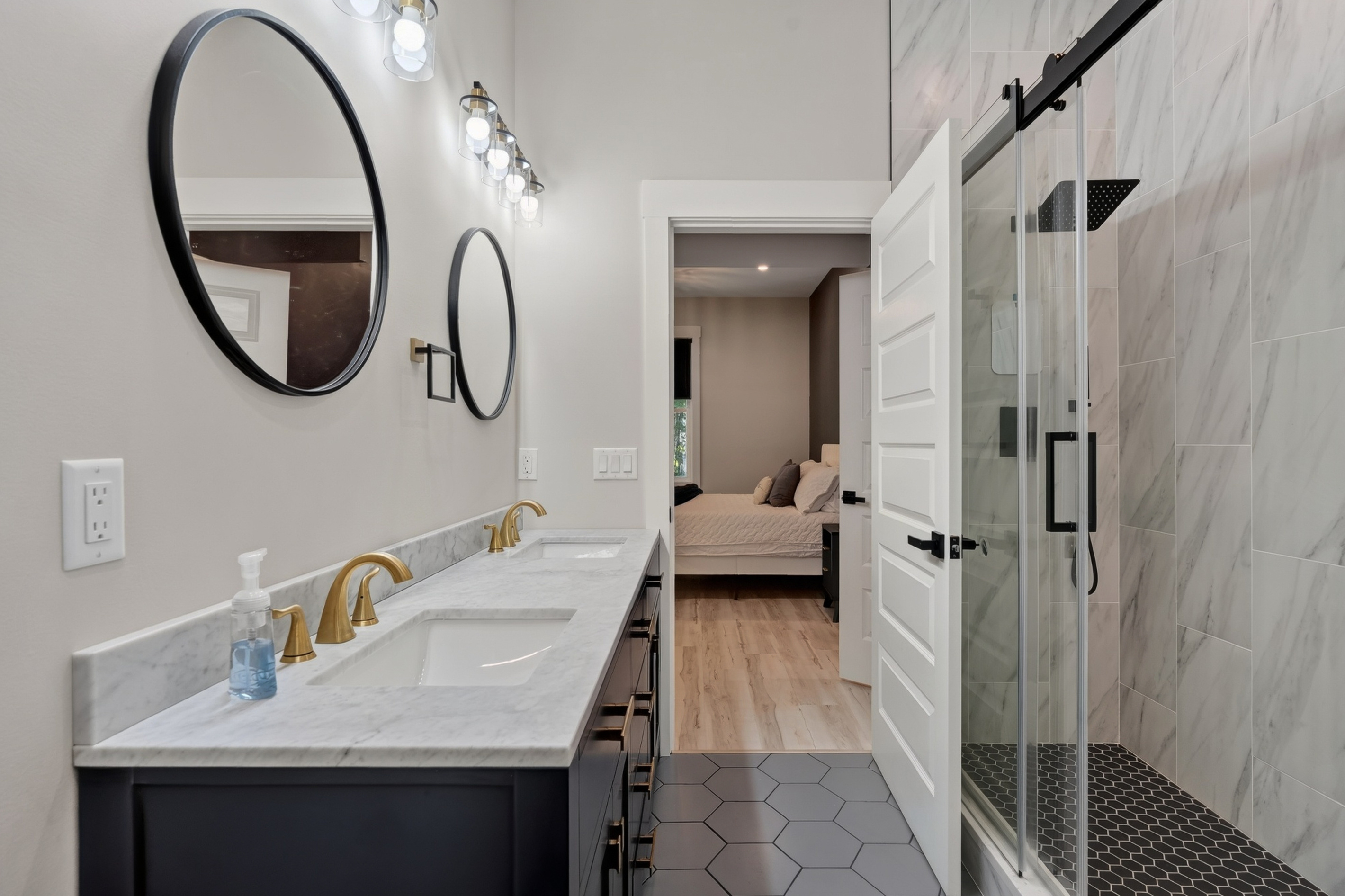 The primary king suite’s private bathroom features a spacious walk-in shower with a rainfall showerhead. A relaxing place to rinse off after a day on Great East Lake.
