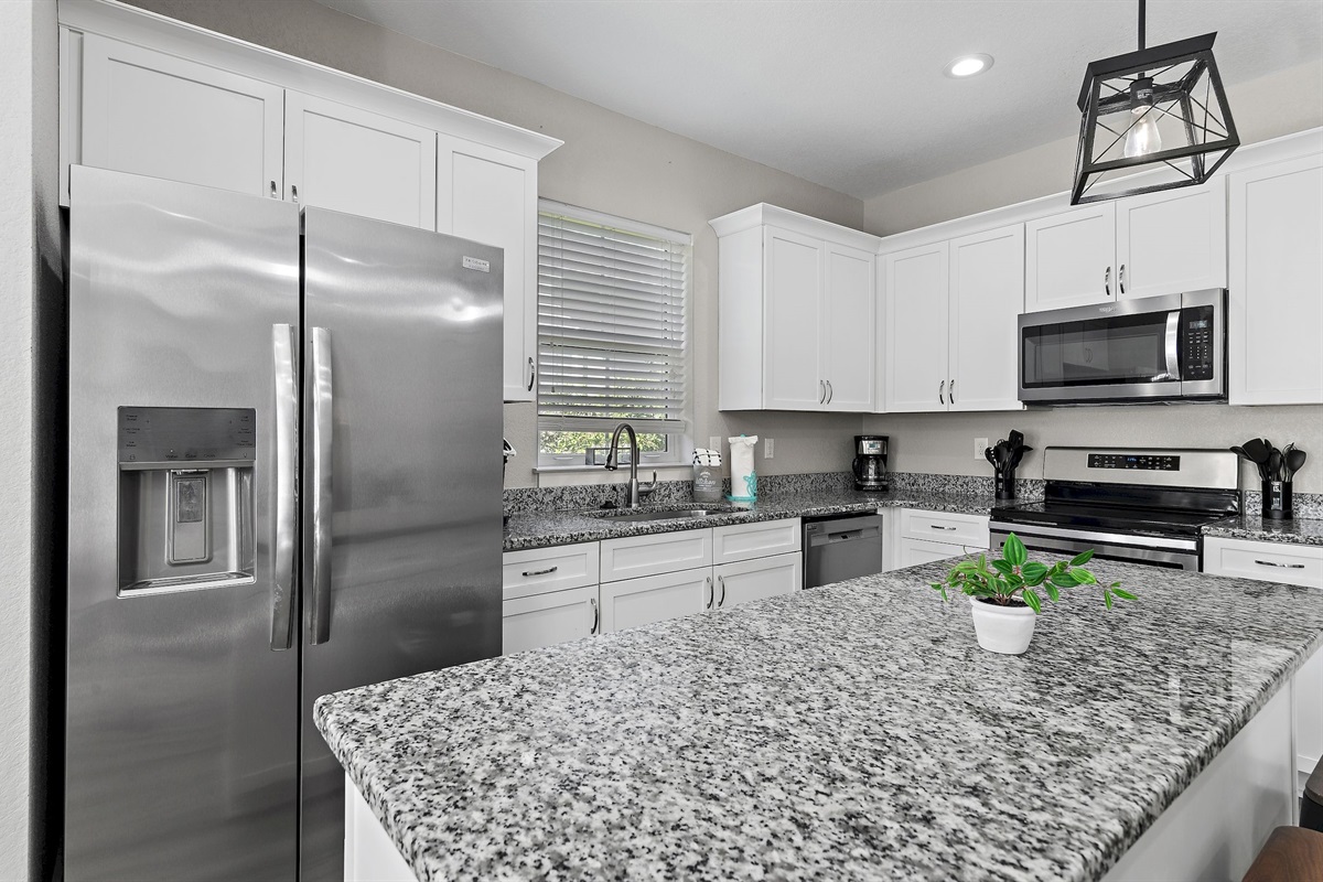 The kitchen is equipped with a large two-door refrigerator with ice maker, stove, oven, coffee-maker and dishwasher.