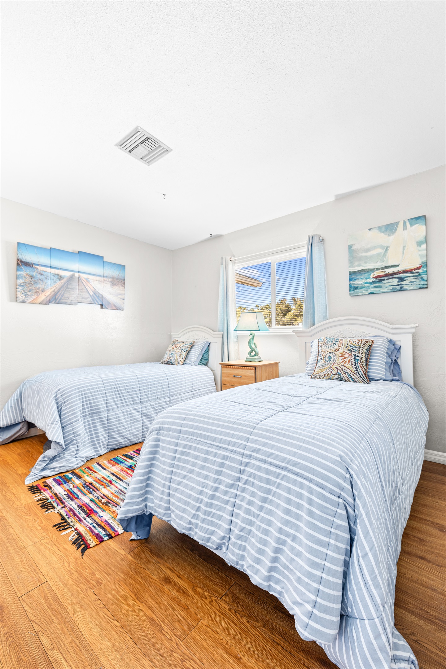 Sand Dollar Room with Two twin beds with linens, a dresser and two closets. 
