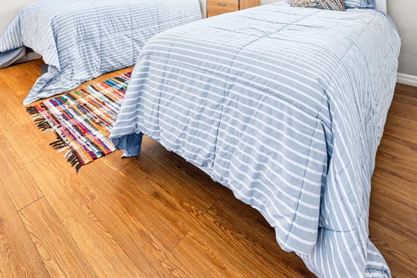 Sand Dollar Room with Two twin beds with linens, a dresser and two closets. 