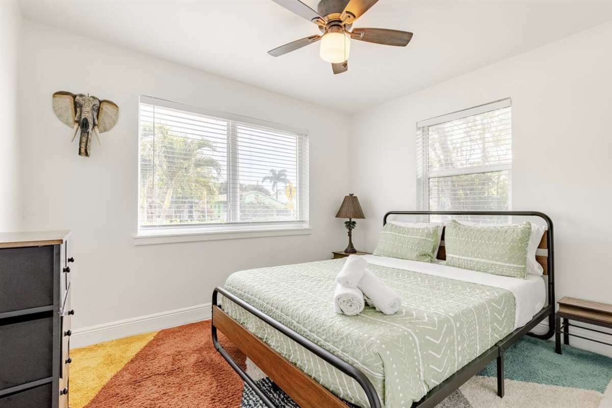 The second bedroom faces the front of the house and also jungle vibes, such as the elephant wall decor.