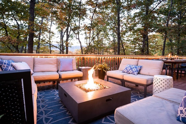 Outdoor lounge area for 10 with propane firepit and mountain ridge backdrop