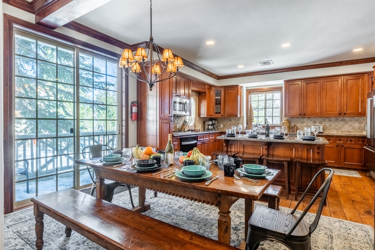 Generous dining table paired with a breakfast bar for additional seating—perfect for shared meals, games, or après planning.