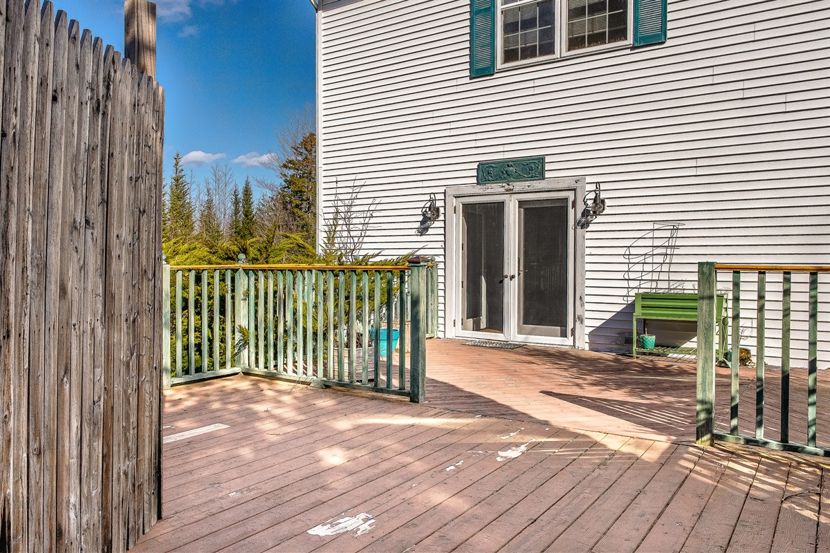 This view showcases the impressive scale of the back deck, looking toward the French doors that lead back into the living room. It’s the perfect hub for indoor-outdoor living, providing ample space for your group to gather on the quiet side of MDI.