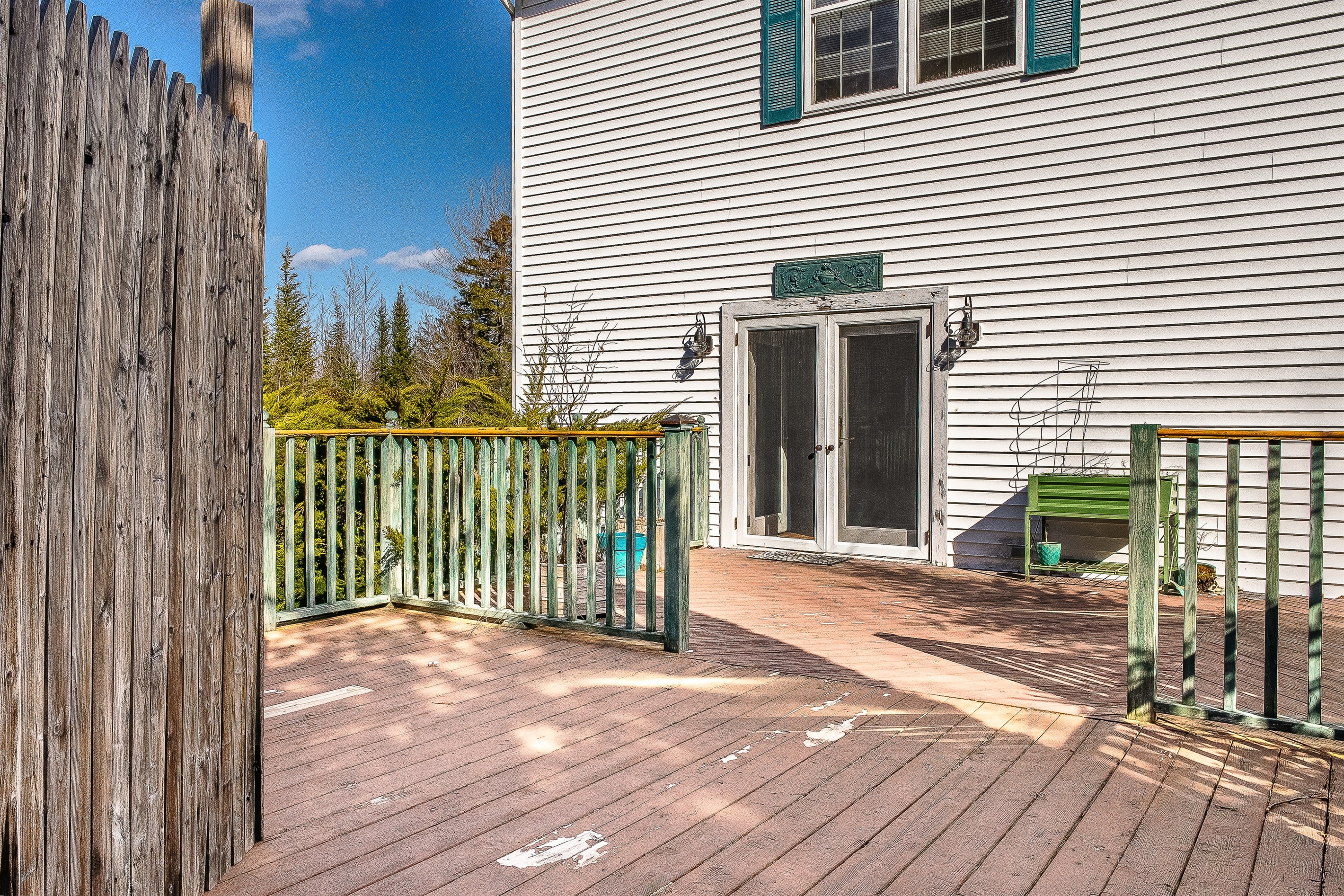 This view showcases the impressive scale of the back deck, looking toward the French doors that lead back into the living room. It’s the perfect hub for indoor-outdoor living, providing ample space for your group to gather on the quiet side of MDI.