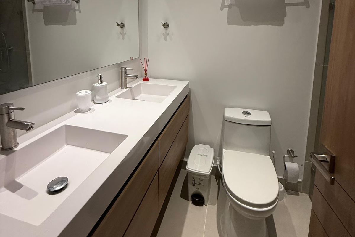 Espacio de baño práctico para tu estancia costera, con tocador doble, espejo y acabados frescos, listo para después de los días de playa y de explorar la zona.
