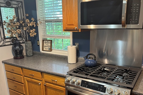 View of the kitchen area with stove and microwave.